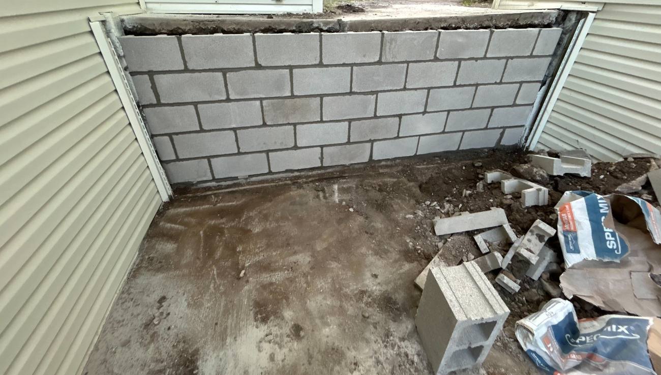 Rebuilt concrete block wall in a window well
