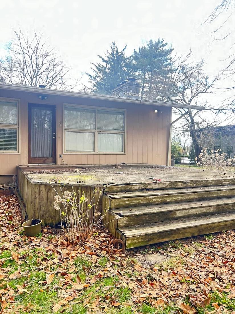 Old weathered deck with rotted boards and broken steps