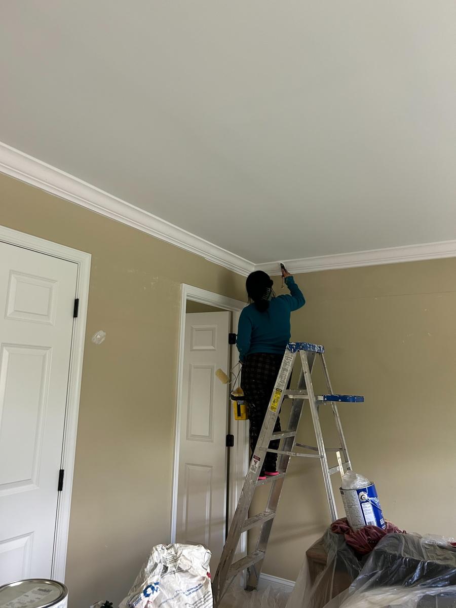 Crew member painting crown molding on a remodeling job